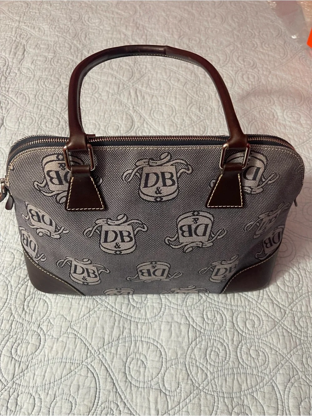 Dooney and Bourke Monogram Denim Donegal Dome Satchel with brown leather trim.